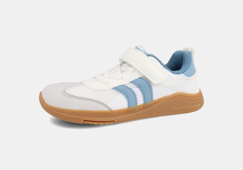 Calçado desportivo barefoot para criança da marca Blanditos by Crio's, modelo Ares, cor branca com detalhes em azul claro e sola de borracha castanha.