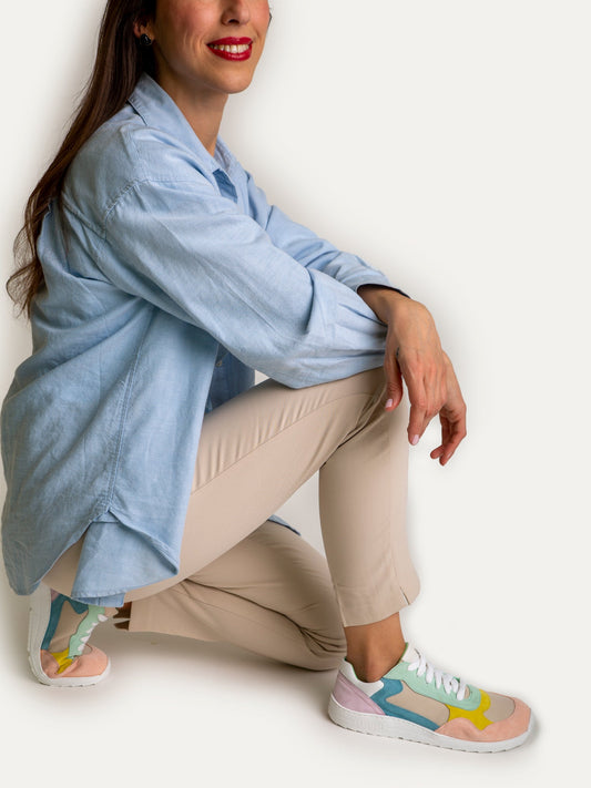Ténis Daniela Pastel MUM em tons pastel usados por uma pessoa sentada, com um look descontraído e confortável.