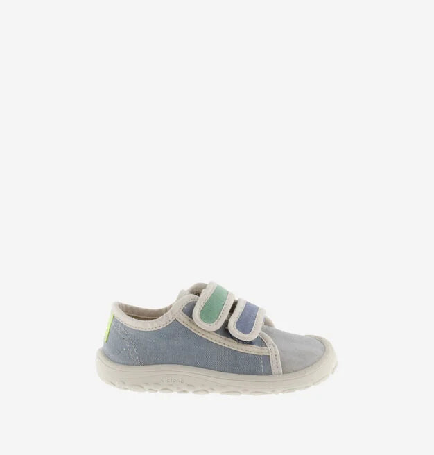 Sapatilha infantil de lona azul, com fecho de velcro, mostrando a lateral e um pequeno detalhe em amarelo néon no calcanhar, em fundo branco.