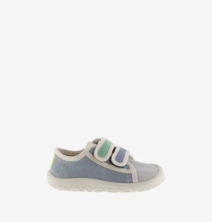 Sapatilha infantil de lona azul, com fecho de velcro, mostrando a lateral e um pequeno detalhe em amarelo néon no calcanhar, em fundo branco.