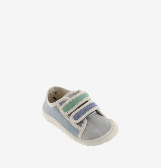 Sapatilha infantil de lona azul clara e cinzenta, com duas tiras de velcro em tons de verde e azul, vista de perfil em fundo branco.
