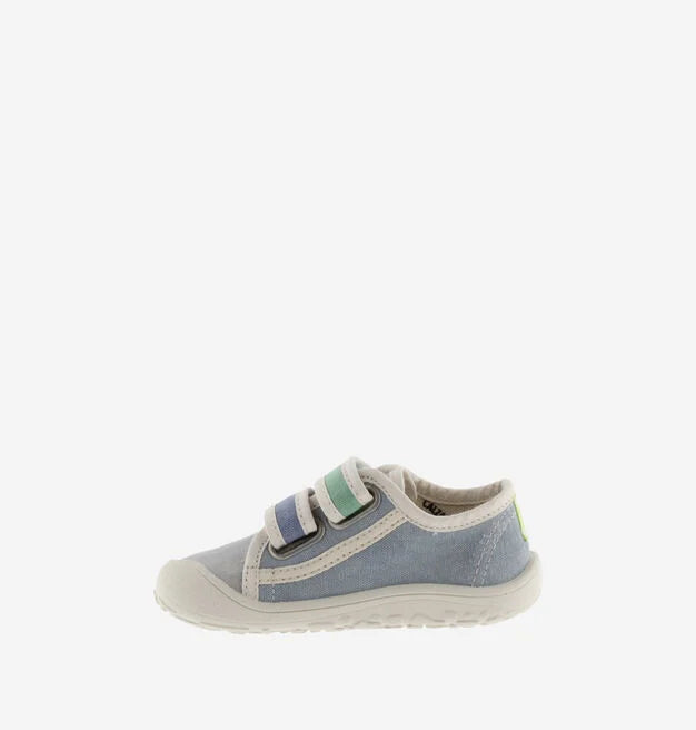 Sapatilha infantil de lona azul, vista de perfil, destacando a sola fina e flexível característica do calçado barefoot, em fundo branco.
