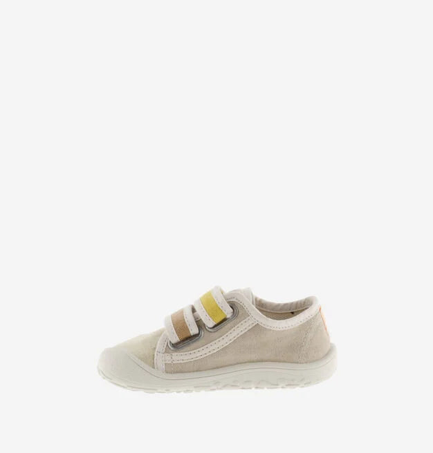 Sapatilha infantil Victoria Barefoot em lona bege, vista lateral, perfil baixo e fecho de velcro.
