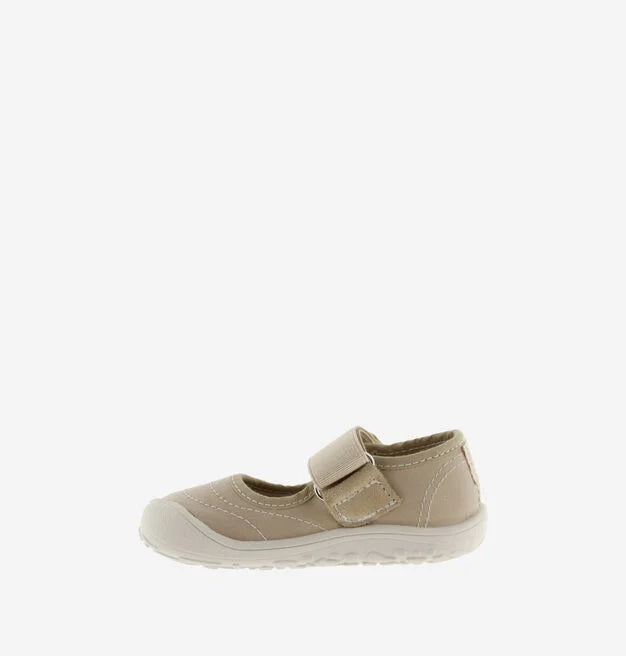 Sapatilha bege de criança estilo bailarina, com fecho de velcro, vista de perfil lateral, focando a parte frontal e a sola.
