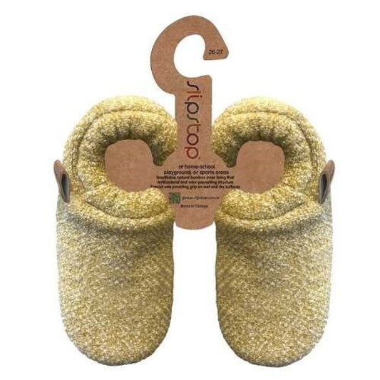 Par de pantufas infantis Slip Stop amarelas/mostarda com etiqueta de cartão pendurada, mostrando a sola antiderrapante.