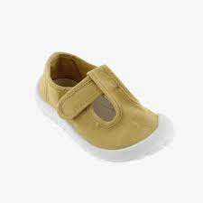 Detalhe de uma sandália infantil Victoria Barefoot em lona trigo, com fecho de velcro e formato largo para liberdade dos dedos.